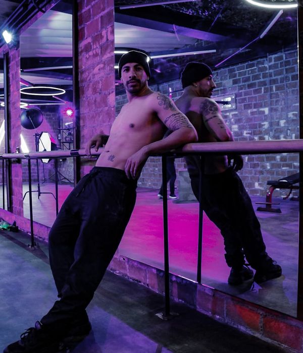 Man performing a dynamic strength exercise in a modern, dark gym.